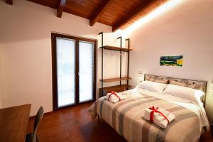 奥托纳IL CAMBUSIERE nature relais的一间卧室,床上有红色的弓