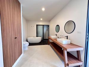 利巴诺伊Rajapruek Samui Resort - SHA Plus的浴室配有两个盥洗盆和浴缸。