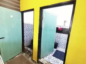 瓜埠Bluewave Sea Out Seaview Homestay的浴室设有两扇绿门和黄色的墙壁