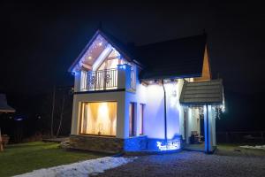 克鲁斯兹考采Modrzewiowa Ostoja II的夜间用圣诞灯点亮的房子
