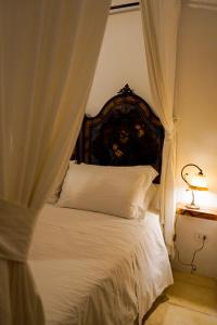 ConventoMasseria Filippo de Raho - Agri Bio Relais的一间卧室配有一张带天蓬的白色床