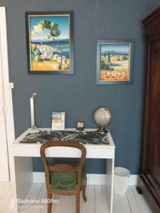 OllierguesChambre Bounty cuisine privée, salle d'eau, terrasse, garage的一张桌子和椅子,旁边是壁画