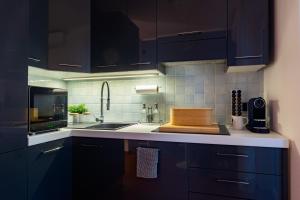 都灵SUNNY SIDE I Turin Suite的厨房配有蓝色橱柜和柜台上的切板