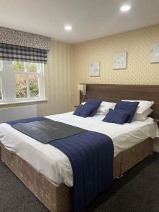 庞特佛雷特国王克罗夫特酒店的一间卧室配有一张带蓝色枕头的大床