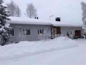 基蒂莱Talo-Villa- 3 mh+s - Kittilä - Levi upea keittiö的前面的雪覆盖的房子