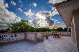 威廉斯塔德Lovely Caribbean family villa with private pool的庭院设有白色的围栏、桌子和雨伞。