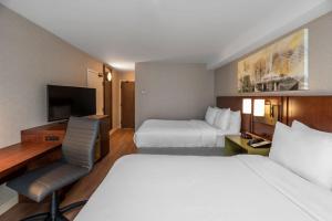汉密尔顿汉密尔顿/斯托尼克雷克康福特茵酒店的酒店客房设有两张床、一张桌子和一台电视。
