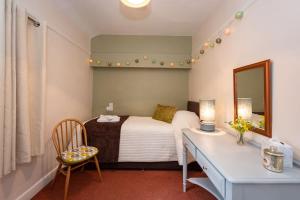 肯德尔Courtyard Flat - Kendal的一间卧室配有一张床、一张书桌和一面镜子