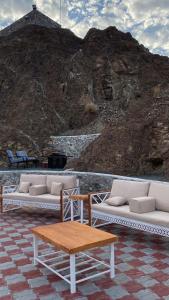 Alhara Lodge استراحة الحارة的一组白色的长沙发和桌子,还有山