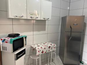 乌巴图巴Apartamento área central的厨房配有微波炉、桌子和冰箱