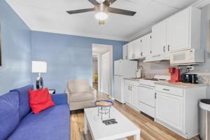圣徒皮特海滩Sunset Beach Suite 2的一间带蓝色沙发的客厅和一间厨房