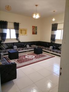 麦地那Khair Jewaar Apartments Al Madinah的带沙发和地毯的客厅