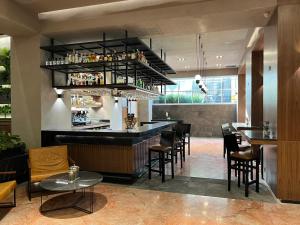 墨西哥城St Isidro Suites Corporate Housing SPA & Wellness Center的餐厅设有酒吧,配有桌椅