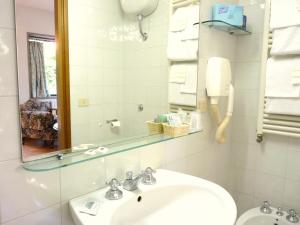 佛罗伦萨克拉西克酒店 的浴室配有盥洗盆、镜子和毛巾