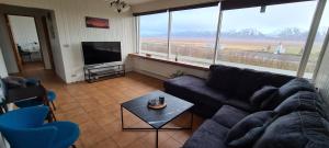 GlaumbærHátún的带沙发和平面电视的客厅