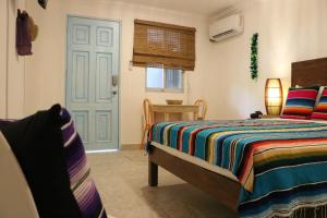 科苏梅尔Hotel Villas Colibrí Suites & Bungalows的一间卧室配有一张床和一个蓝色的门