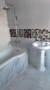 奇帕塔Faigib Guest House的浴室配有白色浴缸和水槽