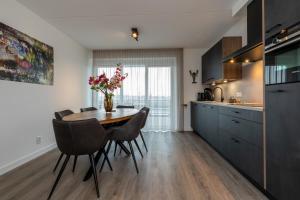 圣安娜兰Appartement Vista Maris, Havenweg 8-1, St. Annaland的厨房以及带桌椅的用餐室。