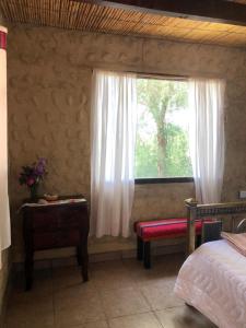 莫利诺斯Matices de Molinos Hostal的一间卧室设有窗户、长凳和桌子