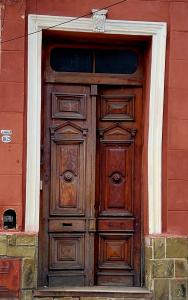 萨尔塔Punto Salta Hostel的红色建筑一侧的木门