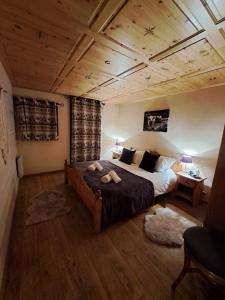 沙泰勒Chalet de montagne style savoyard, vue sur pistes的一间卧室设有一张大床和木制天花板