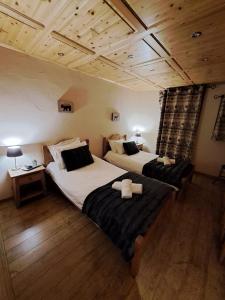 沙泰勒Chalet de montagne style savoyard, vue sur pistes的铺有木地板的客房内的两张床