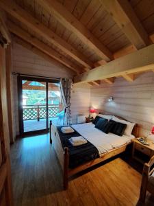 沙泰勒Chalet de montagne style savoyard, vue sur pistes的一间带一张大床的卧室,位于带窗户的房间内