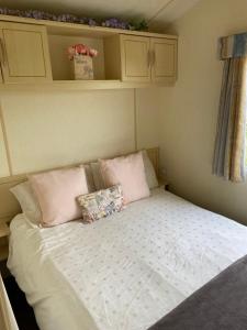 Littlestone-on-SeaRomney sands privately owned comfy caravan的一张床上有两个枕头的房间