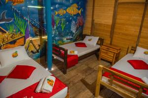 布兰卡滩Nuestros Tres Tesoros II的一间设有两张床和鱼主题墙壁的客房