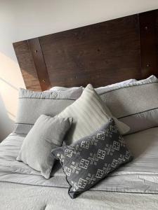 危地马拉Apartamento de lujo, MODERNO estilo NEW YORK的一张带枕头和木制床头板的床