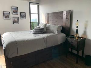 危地马拉Apartamento de lujo, MODERNO estilo NEW YORK的一间卧室配有一张大床和木制床头板