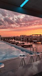 圣达菲洛斯西洛斯酒店的一座享有日落美景的建筑屋顶上的游泳池