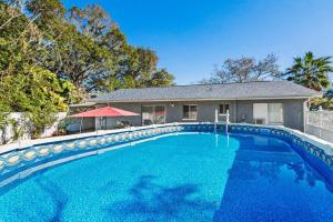 皮内拉斯公园Gorgeous Heated Pool House Near Gulf Beaches!的一座大蓝色游泳池,位于房子前