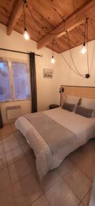 拉康提内勒Maisonette de pays classée 3 étoiles的一间带一张大床的卧室,位于一个拥有木制天花板的房间