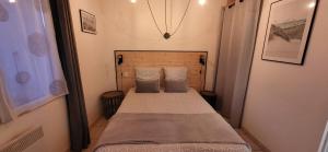 拉康提内勒Maisonette de pays classée 3 étoiles的一间小卧室,配有带两个枕头的床