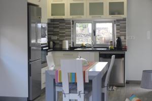 BiscoitosPedras Negras House的厨房配有桌椅和冰箱。