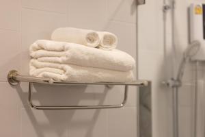 清迈AMIRI PLACE HOTEL的浴室毛巾架上的一堆毛巾