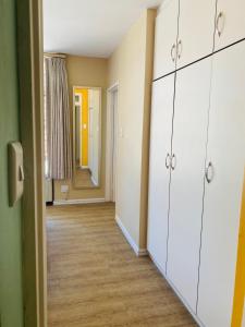 德班Oceanic 2 Bedroom - Self-catering Apartment的一间空房间,有白色的橱柜和走廊