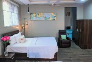 特马Lady M guest House的卧室配有白色的床和椅子