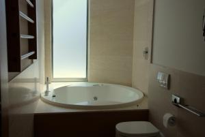 瓦多利古雷Sea Art Hotel的带浴缸、卫生间和窗户的浴室