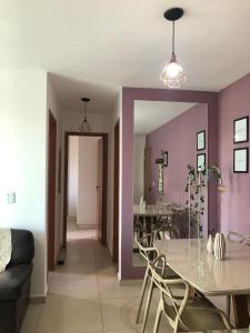 乌贝兰迪亚Apartamento próximo ao Parque e Aeroporto - com academia e piscina的一间拥有紫色墙壁和桌椅的用餐室