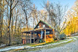 Tellico PlainsCozy Tellico Plains Cabin with Large Mountain Creek!的地面上积雪的树林中的小木屋