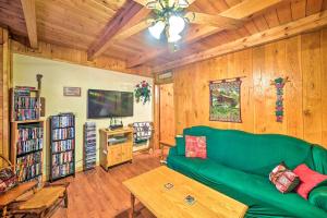 Tellico PlainsCozy Tellico Plains Cabin with Large Mountain Creek!的客厅设有绿色沙发和木墙