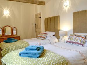 韦斯特尔顿The Wood Shed - E1919的客房内的两张床,上面有蓝色的毛巾