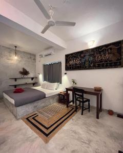 阿斯高Namaste Jungle - A Boutique Homestay的一间卧室配有一张床、一张桌子和吊扇