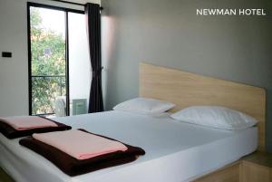 Ban Khlong HaNewman hotel的一张带两个枕头和窗户的大型白色床
