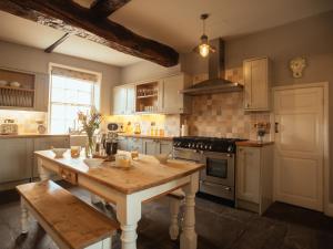 约克Manor House的厨房配有木桌和炉灶。