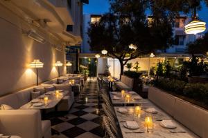 洛杉矶Short Stories Hotel的晚上在庭院里设有桌椅的餐厅