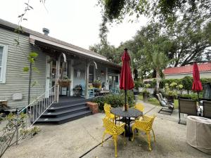 新奥尔良Bywater Home, Parking and Pet Friendly Retreat的庭院配有桌椅和遮阳伞。