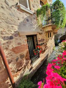 明乔河畔的瓦雷奇奥Una Rosa sul Mincio的一座石头建筑,上面有鲜花